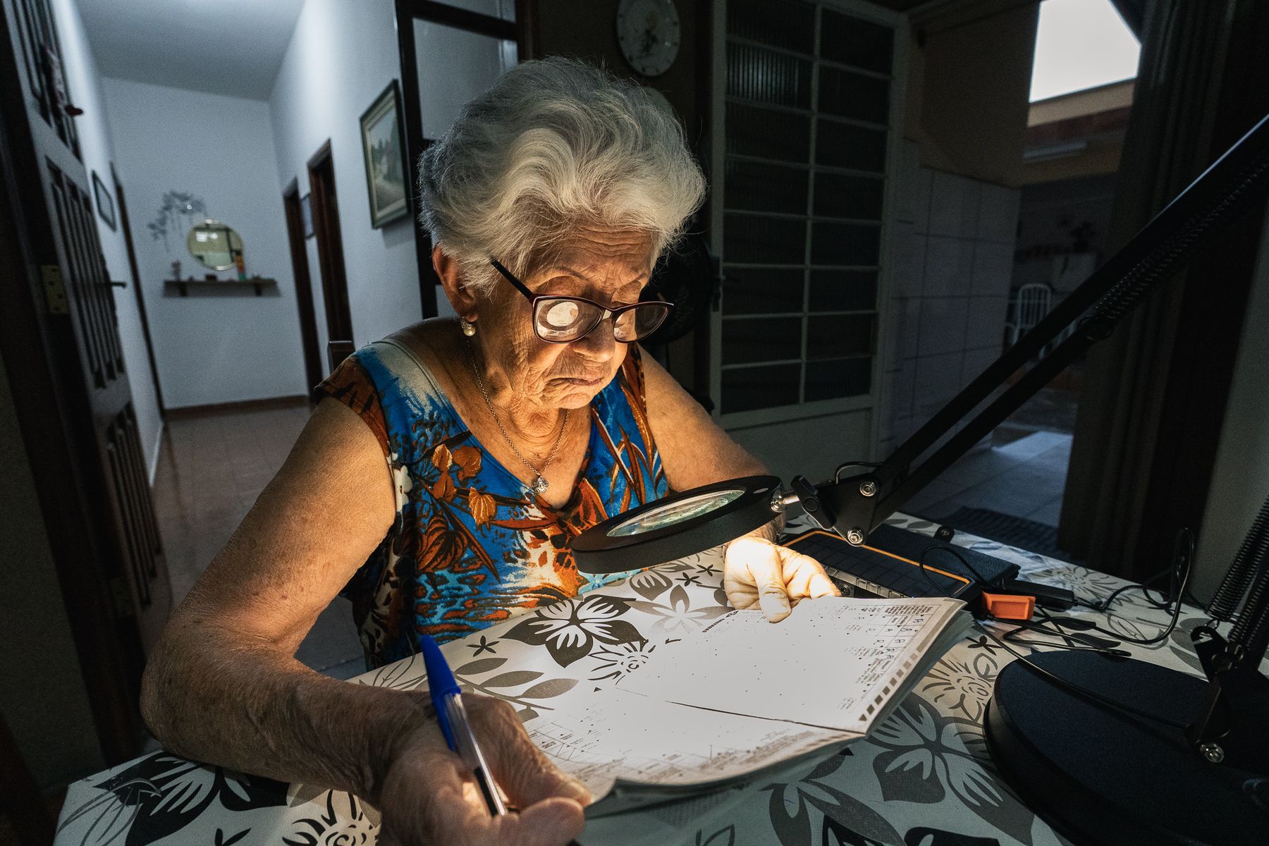Maria Clara reading with a lit magnifying glass